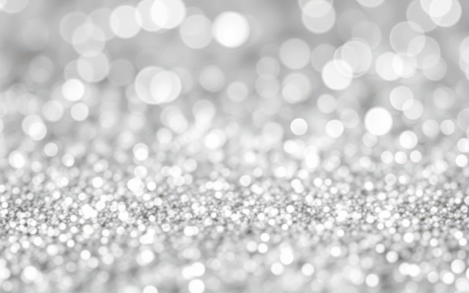 Sparkling silver glitter fills the surface, reflecting light and creating a shimmering effect during a special event or celebration